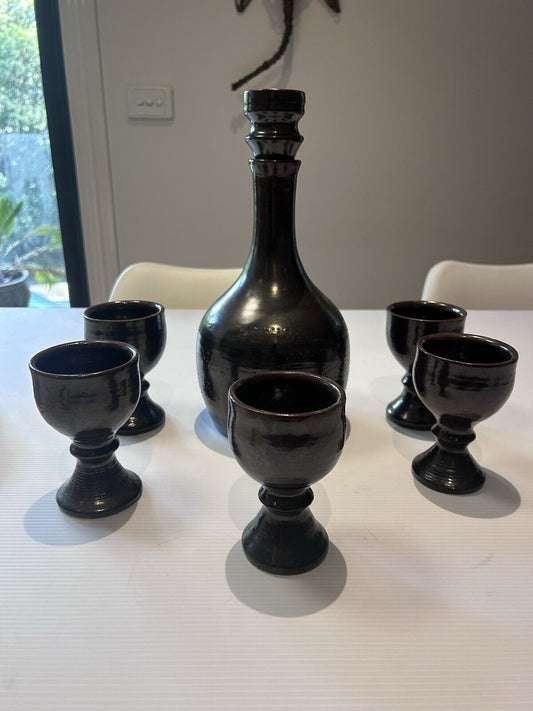 CHARLES WILTON SIGNED VINTAGE POTTERY DECANTER WITH STOPPER AND FIVE GOBLETS.